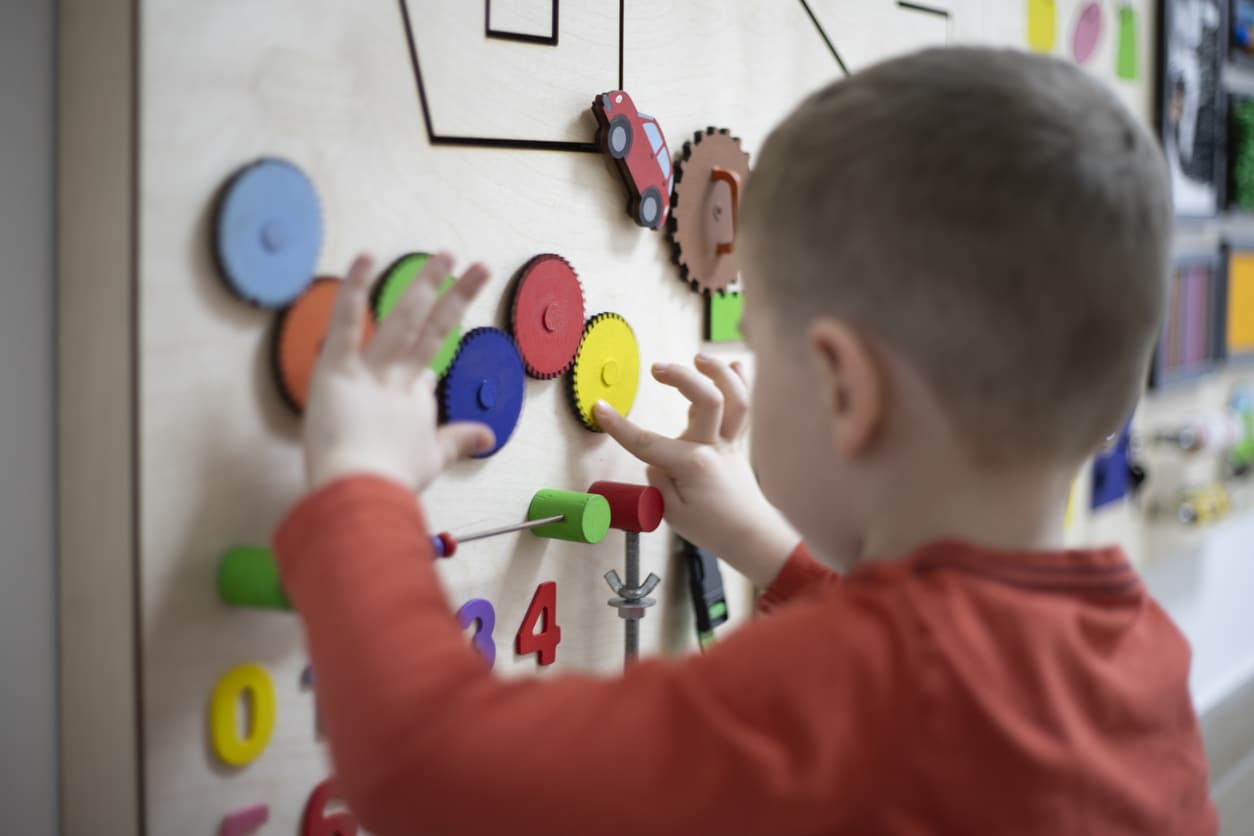 Young boy with autism playing at a sensory wall