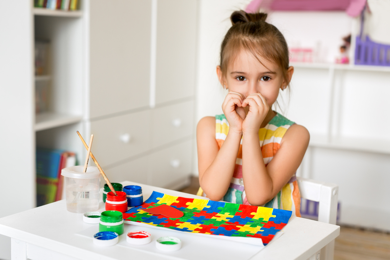 a preschool-aged girl paints in an ABA center