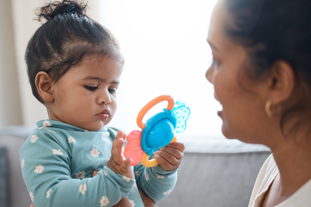 young girl playing with a toy while expressing early signs of autism in babies and toddlers